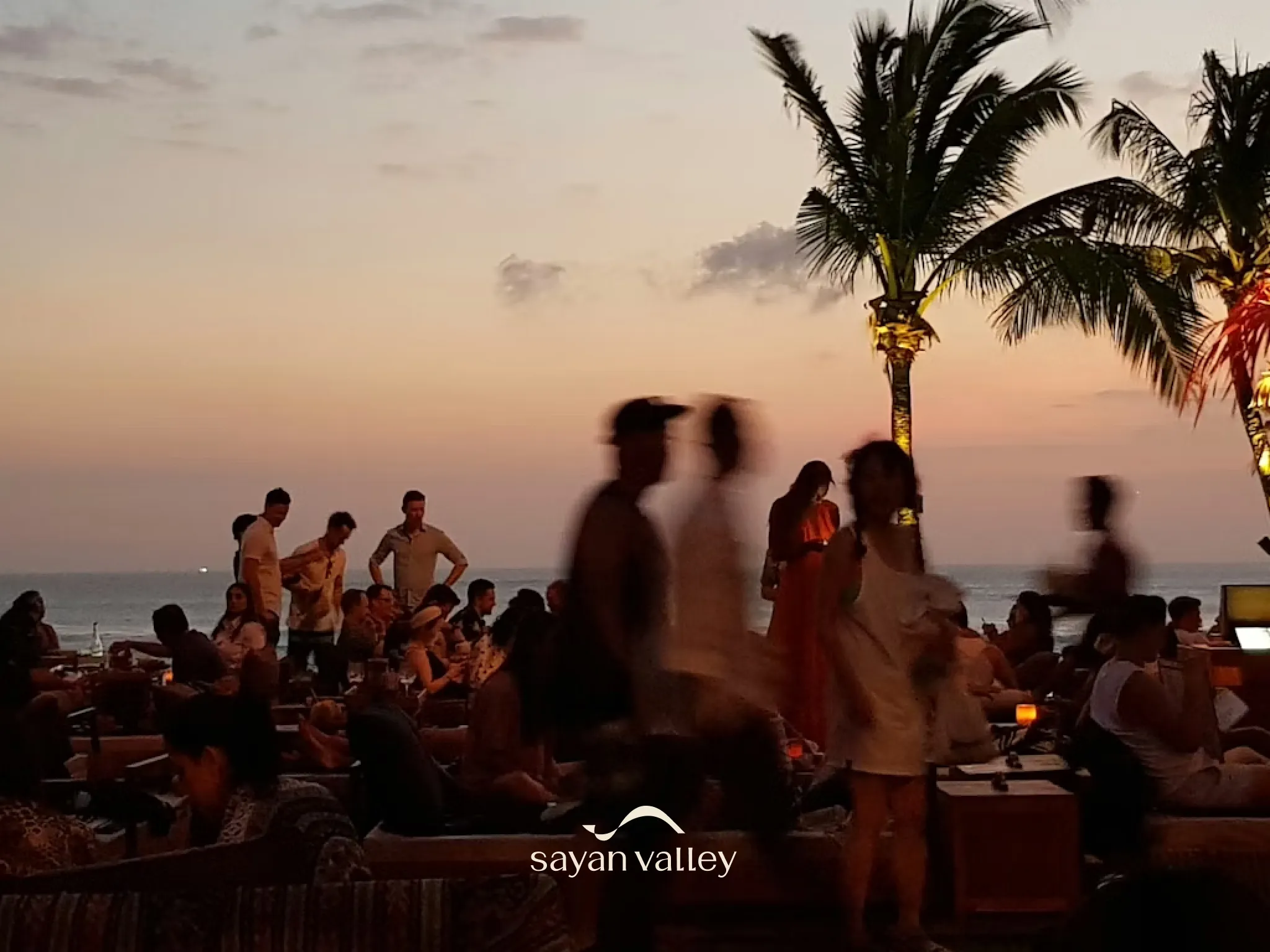 cocktail-party-at-bali Silhouette of a waiter serving drinks at a beach club during the peak bali sunset time.