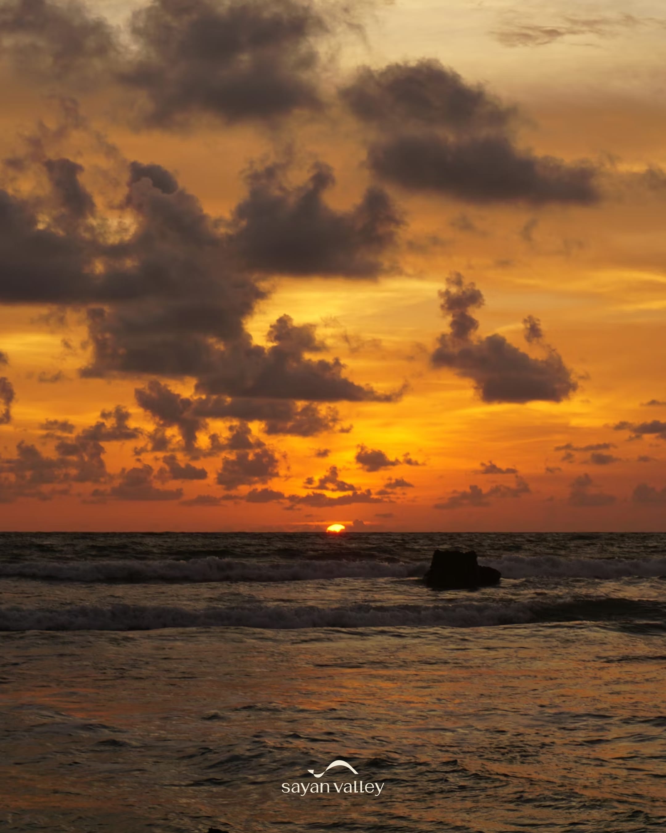 A breathtaking view of the sun dipping below the ocean horizon exactly at bali sunset time.