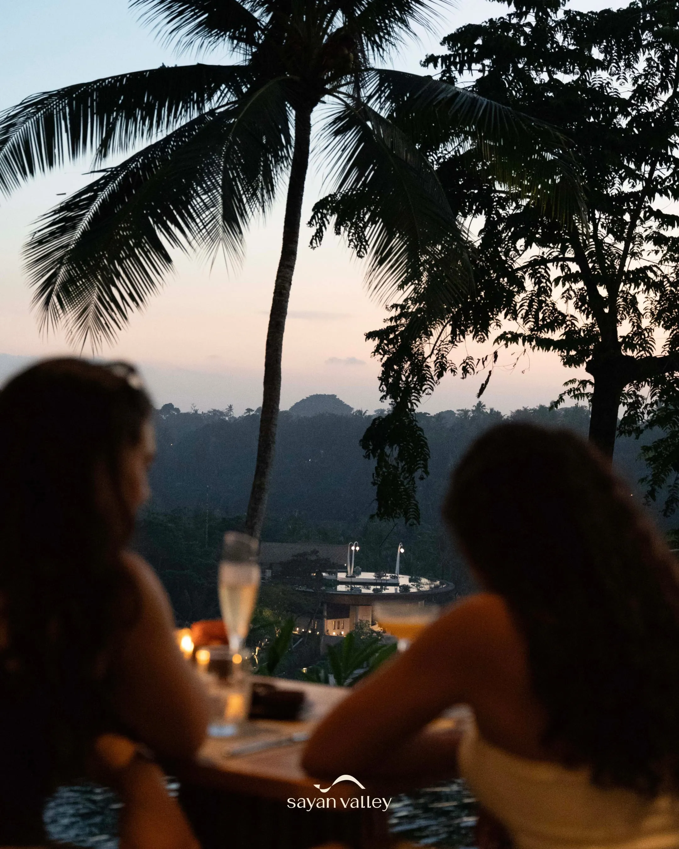 sayan-valley-ubud-bali-sunset-dinner-view Friends enjoying a wine dinner at a luxury restaurant during the peak sunset time in bali