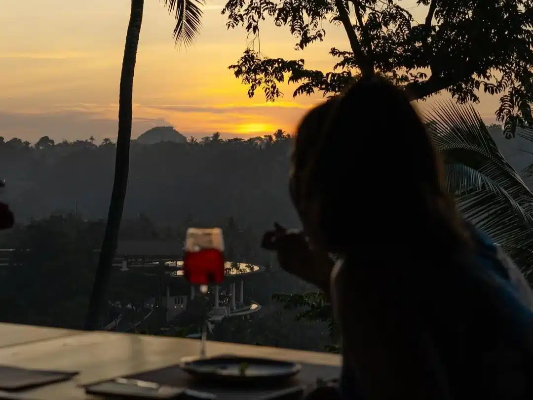 Silhouette of a waiter serving drinks at a beach club during the peak bali sunset time.